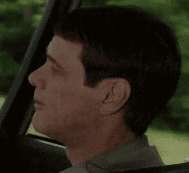a man in a car is making a funny face with the words connardvirus connardvirus below him