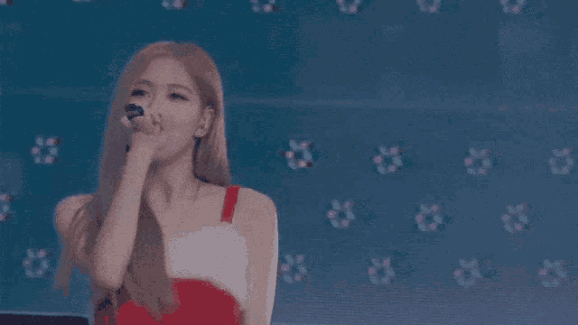 a woman is singing into a microphone on a stage