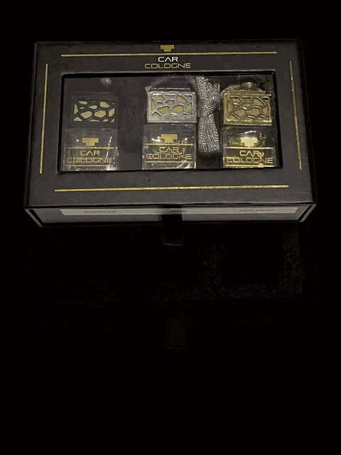 three bottles of car cologne sit in a black box