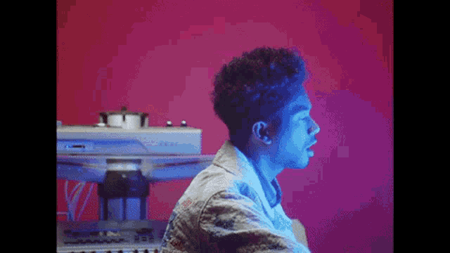a young man is sitting in front of a keyboard in a dark room .