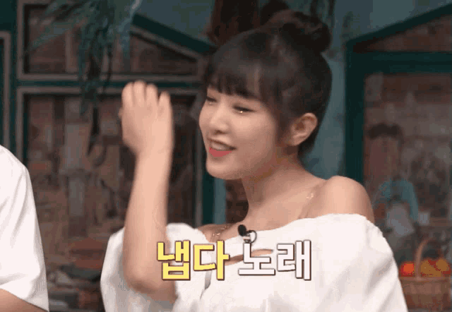 a woman in a white off the shoulder top has korean writing on her arm