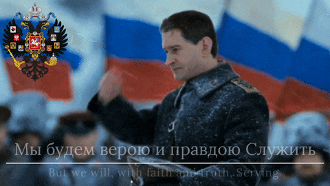a man stands in front of a russian flag and a coat of arms