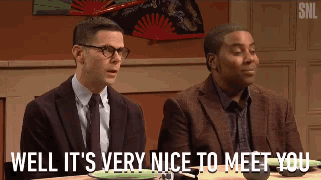 two men are sitting at a table and one of them says well it 's very nice to meet you .