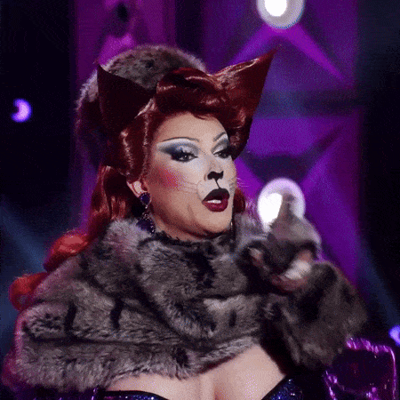 a drag queen dressed as a cat with a fur coat