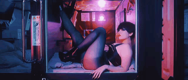 a woman is laying in a box with a sign on the door that says ' warning ' on it