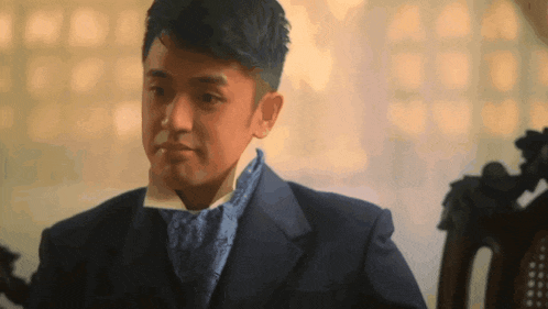 a man in a suit and tie is sitting down