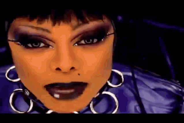 a close up of a woman 's face with a lot of makeup and earrings .