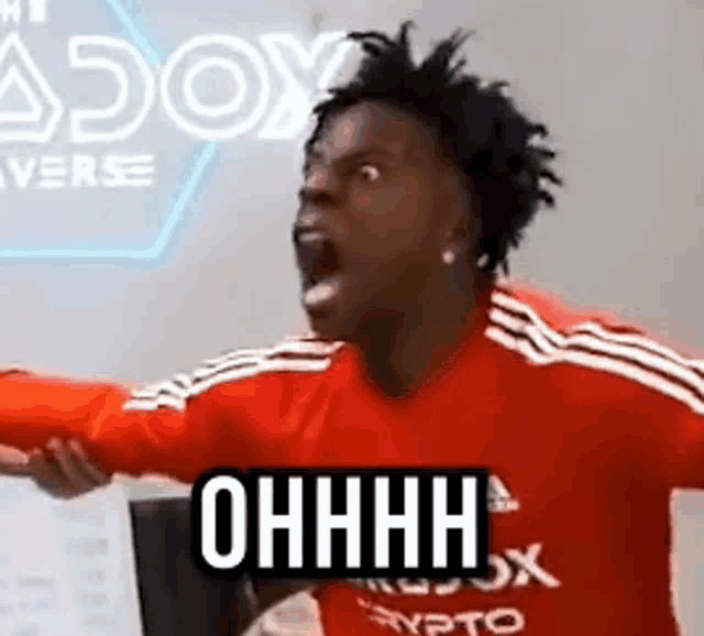 a man in a red shirt is screaming and pointing at something while wearing a red shirt .