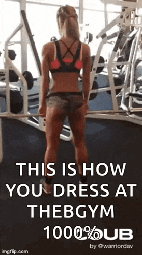 a woman is standing in a gym wearing shorts and a bra .