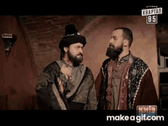 two men are standing next to each other in a room with a sign that says " make a gif.com " on the bottom