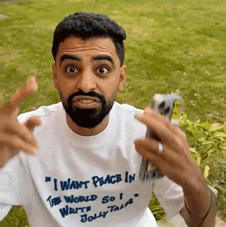 a man with a beard is wearing a shirt that says " i want peace in the world so i write jolly tales "