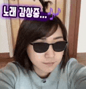 a woman wearing sunglasses is taking a selfie with a music note on her head .