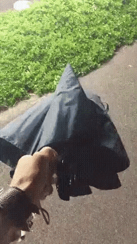 a person is holding an umbrella on a sidewalk in the rain