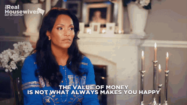 a woman is sitting in front of a fireplace with the words " the value of money is not what always makes you happy " displayed