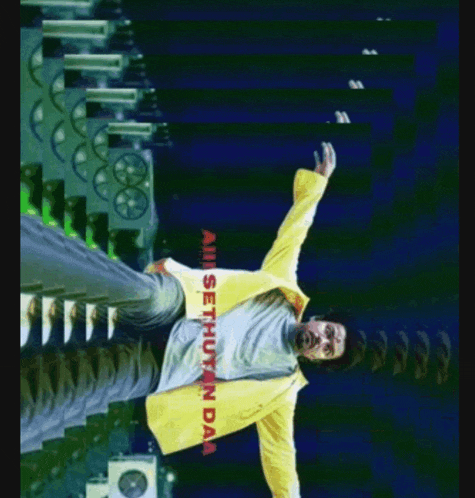 a man in a yellow jacket is standing in front of a building with the words all sethuyan da on the bottom