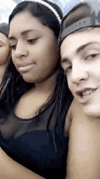 a man and a woman are standing next to each other . the woman is wearing a headband .