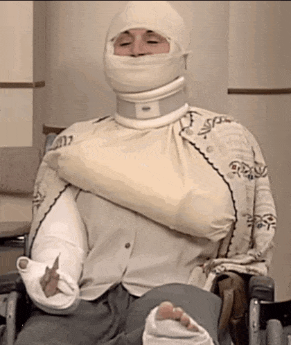 a man in a wheelchair has a bandage on his head and arm