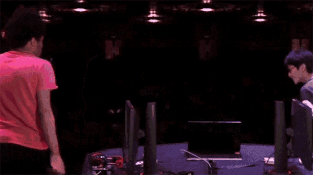 two men shake hands in front of a crowd of people