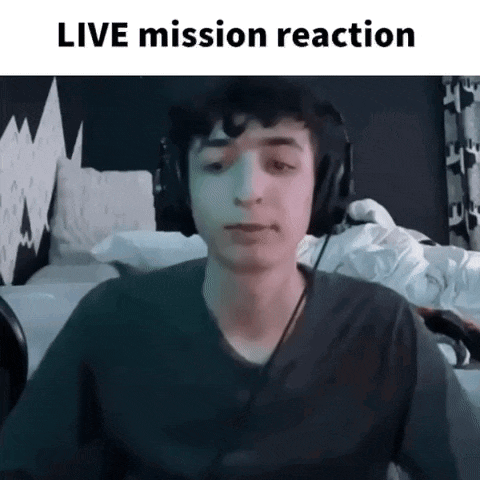 a young man wearing headphones is sitting in front of a computer screen with the words live mission reaction written above him .
