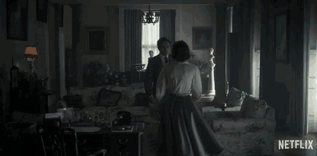 a man and woman are dancing in a living room with a netflix logo on the bottom right