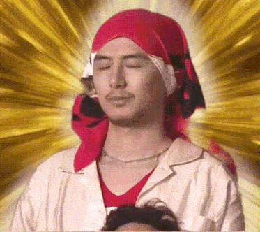 a man with his eyes closed wearing a red bandana