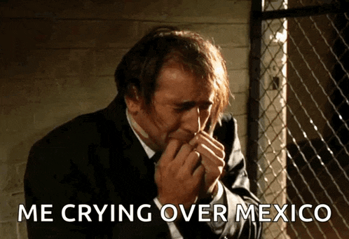 a man in a suit is crying over mexico and covering his mouth with his hands