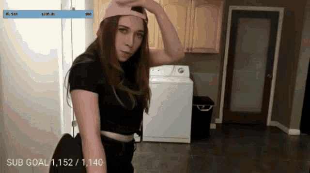 a woman is standing in front of a washer and dryer with a sub goal of 1,152/ 1,140