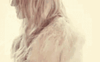 a woman wearing a fur coat is standing in front of a white background .