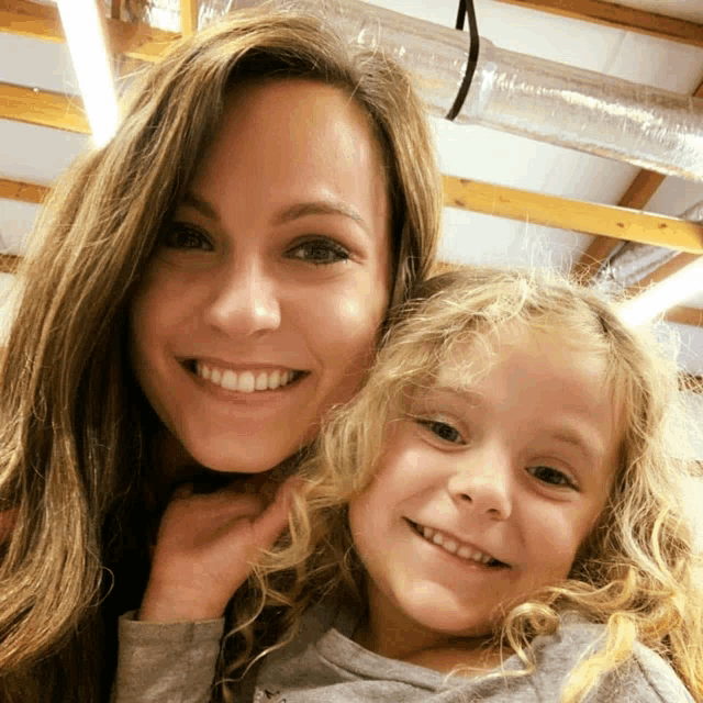 a woman and a little girl smile for the camera