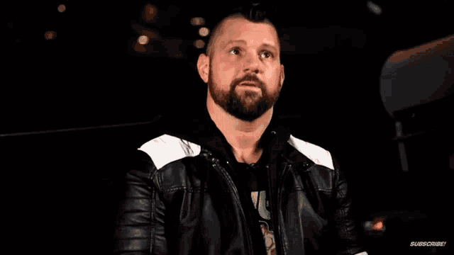 a man with a beard is wearing a leather jacket and says honor no more