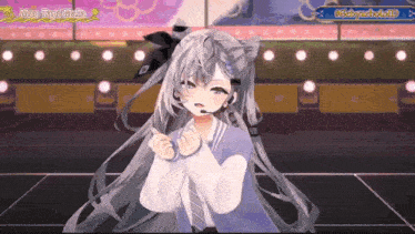 a girl with long gray hair and a microphone on her head is standing on a stage .