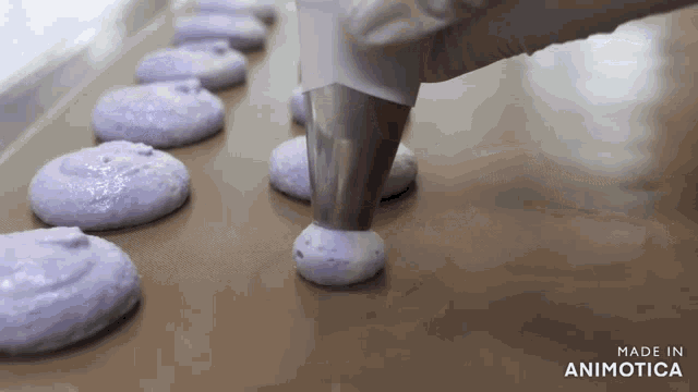a row of purple cookies are being made by made in animatica