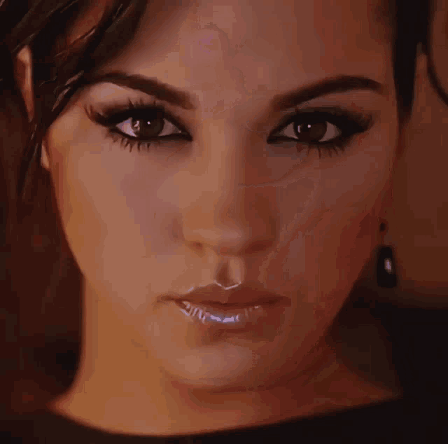 a close up of a woman 's face with long eyelashes and earrings