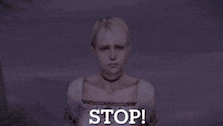 a woman is standing in front of a purple background and says stop