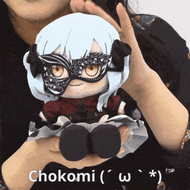 a woman is holding a stuffed doll with chokomi written on the bottom