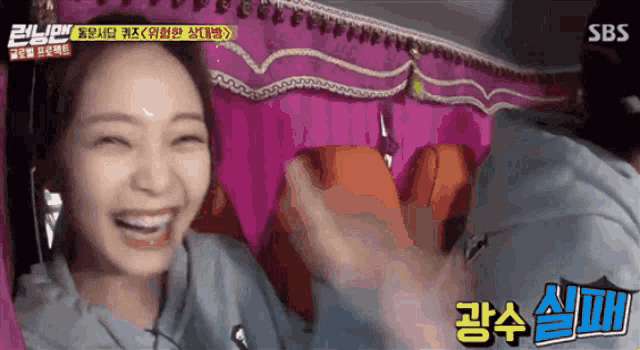 a woman is smiling in front of a sbs sign