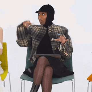 a woman wearing a balaclava is sitting in a chair