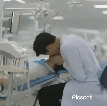 a dentist is kissing a patient 's neck in a dental office .