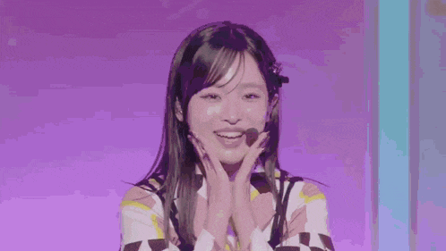 a young woman is standing on a stage with a microphone in her mouth and wearing a checkered shirt .
