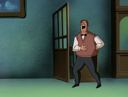 a man in a vest and bow tie is laughing with his mouth open