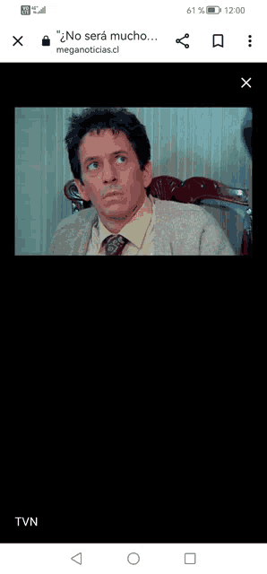 a man in a sweater and tie is on a cell phone screen