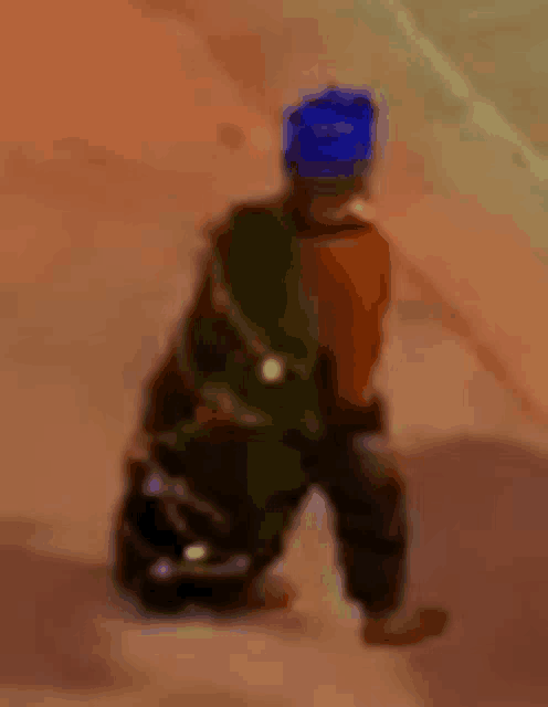 a cartoon character with a blue hat is kneeling down .