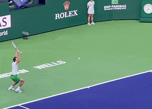 two tennis players are playing on a court with an emirates ad behind the net
