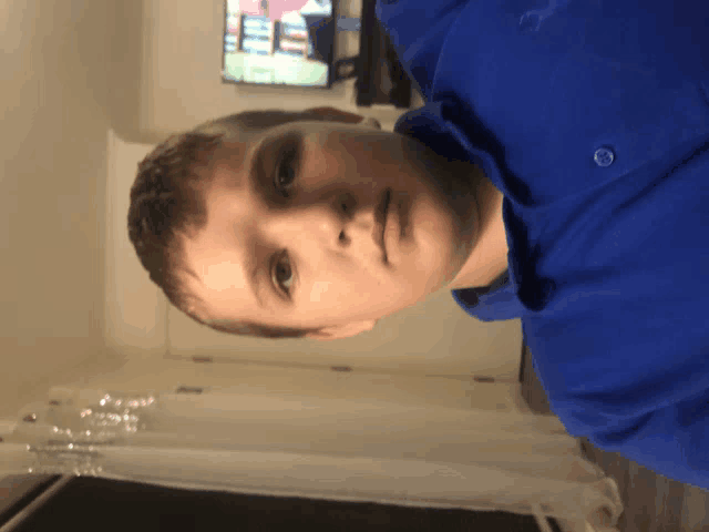 a young boy wearing a blue shirt is looking down at the camera