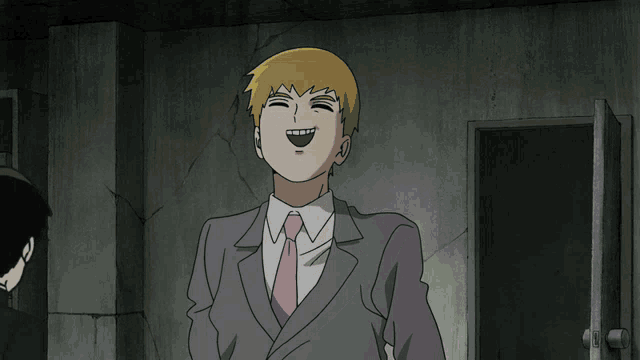 a man in a suit and tie is laughing in a dark room