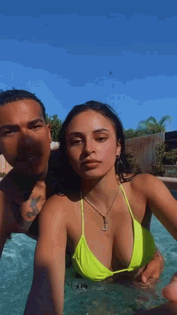a man and a woman are taking a selfie in a swimming pool .