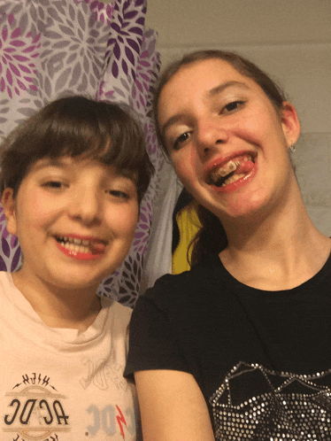 a girl with braces on her teeth is wearing a shirt that says ' acdc ' on it