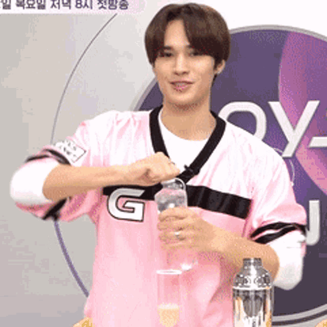 a man wearing a pink jersey with the letter g on the front