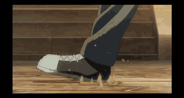 a close up of a person 's foot walking on a wood floor