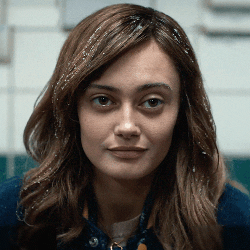 a close up of a woman 's face with a blue shirt on